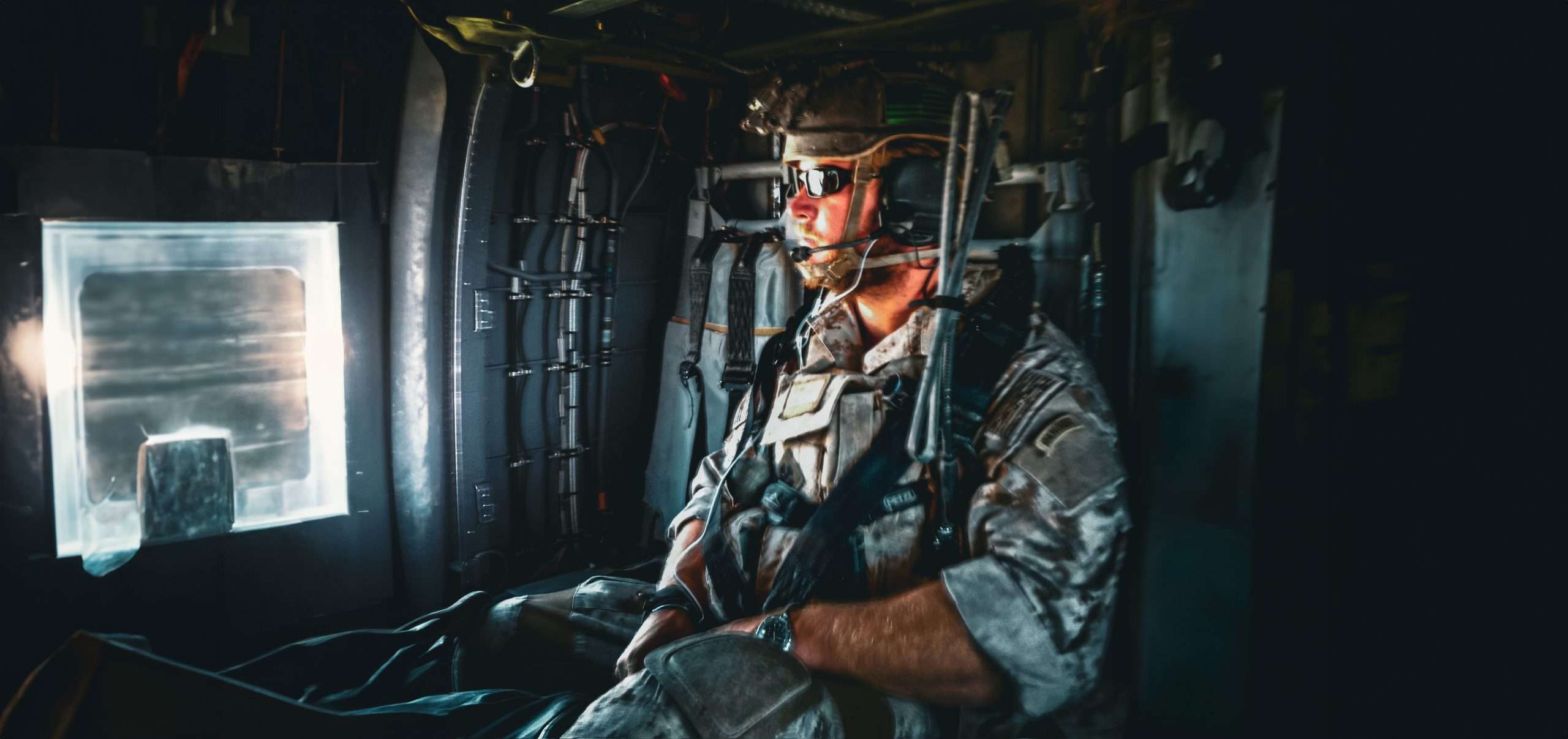 Purple heart recipient, Navy Seal officer, Tim Sheehy in military combat gear aboard a helicopter.